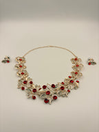 Necklace with red stones and matching earrings on a light gray background