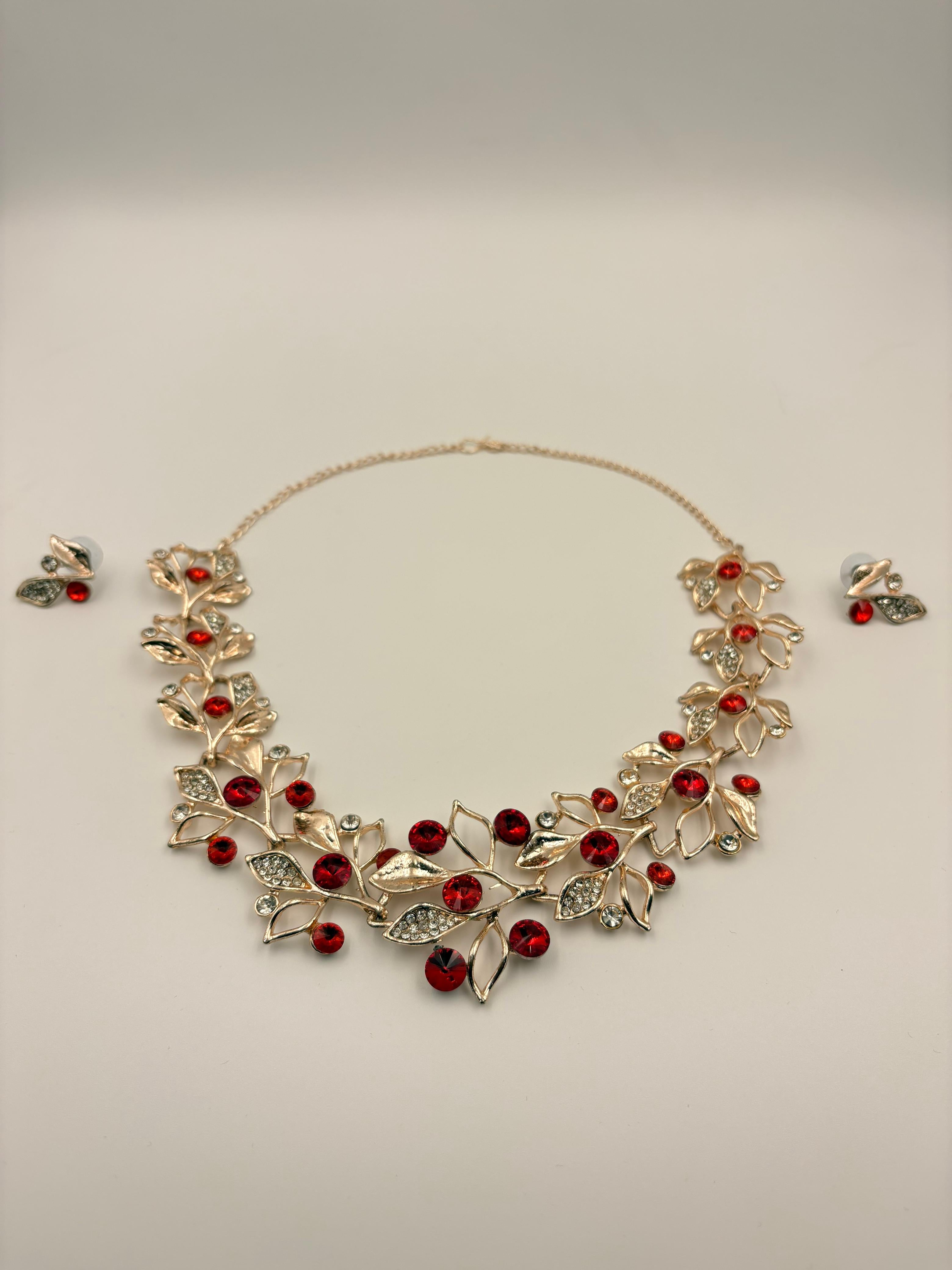 Necklace with red stones and matching earrings on a light gray background